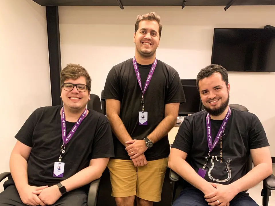 Três desenvolvedores da Téxvn Group, nossa software house, no escritório em 2022